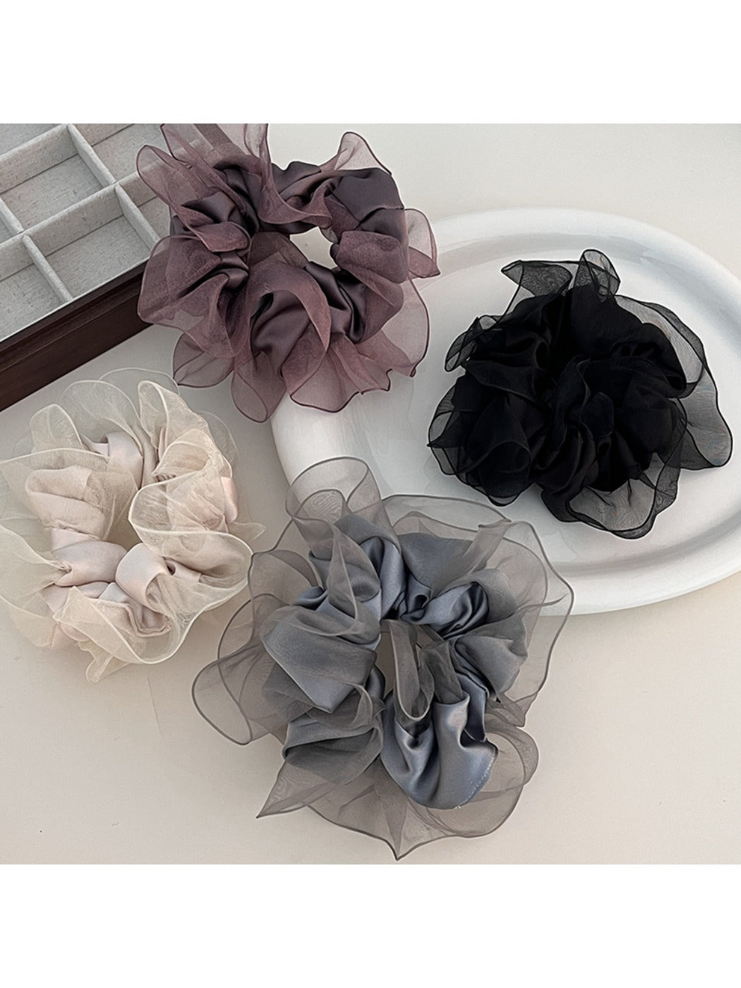 Classic solid color ruffled scrunchie in soft fabric, styled on a white background