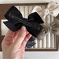 Beau satin bow hair clip styled in long brown hair