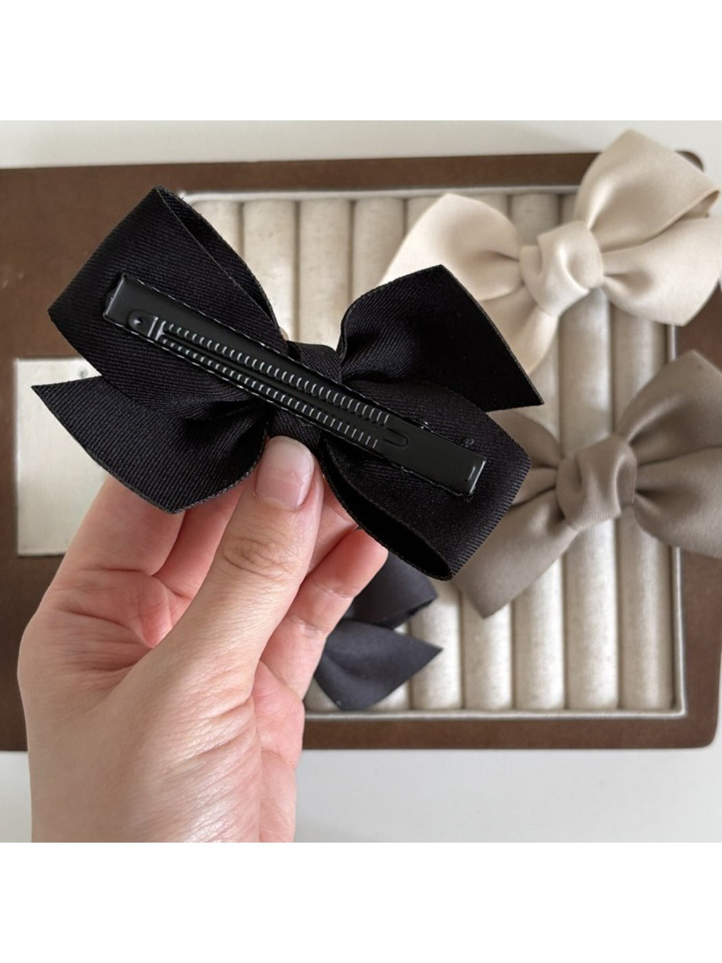 Beau satin bow hair clip styled in long brown hair