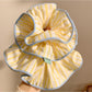 Yellow striped scrunchie wrapped around a ponytail on a model