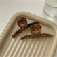 Beau acetate brown style claw clip on white background showing curved design