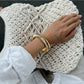 Lovra Chic Irregular Bangle Bracelet resting on textured fabric background