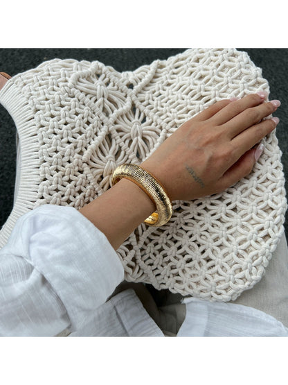 Lovra Chic Irregular Bangle Bracelet resting on textured fabric background