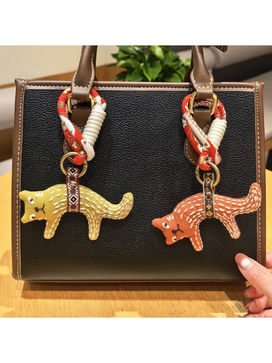 Close-up of adorable fox charm keychain with orange and white enamel details