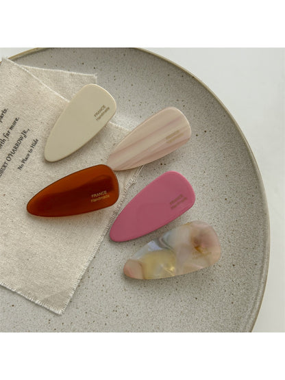 Beau pink tone hair clip held in hand showing size and shape