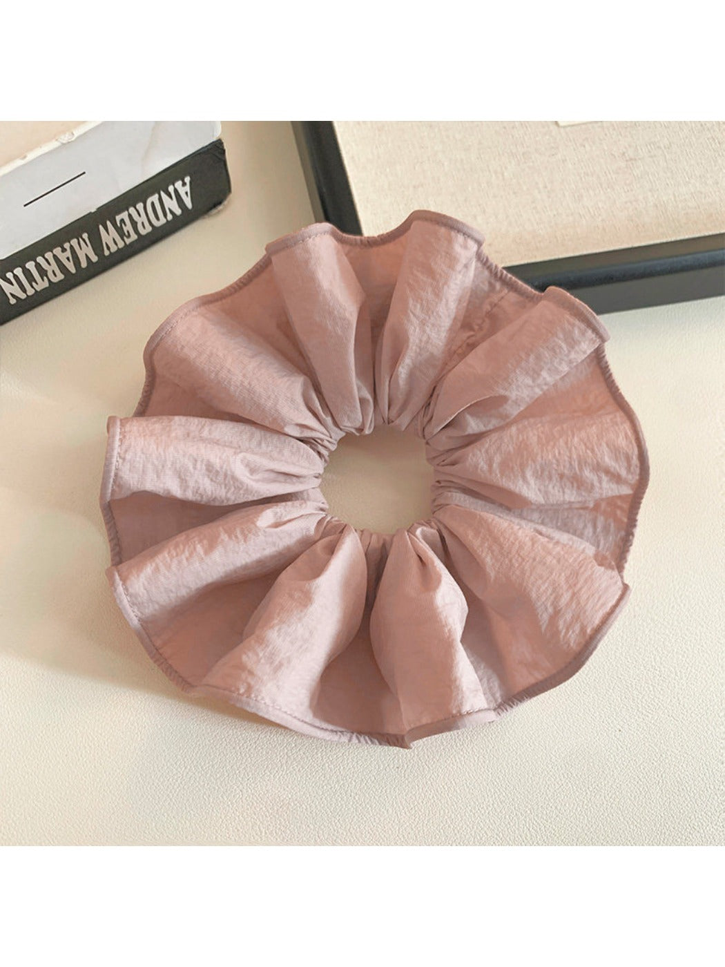 Close-up of soft pink scrunchie fabric texture and stitching details