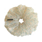 Green tulle scrunchie with small white and pink flowers displayed on a white background