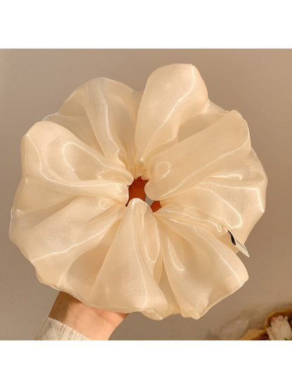 Gifty minimalist shiny scrunchie worn in a ponytail on dark hair