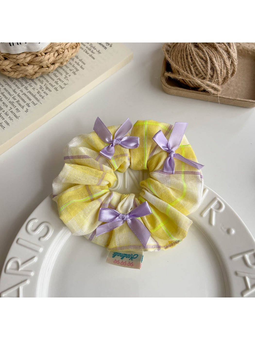 Gifty Ribbon Bow Plaid Scrunchie styled in a model's hair with a casual outfit