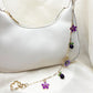 Daisy pendant bag charm displayed on a wooden surface with soft lighting
