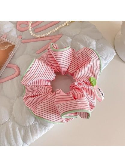 Gifty scrunchie in beige and white stripes on a wooden table