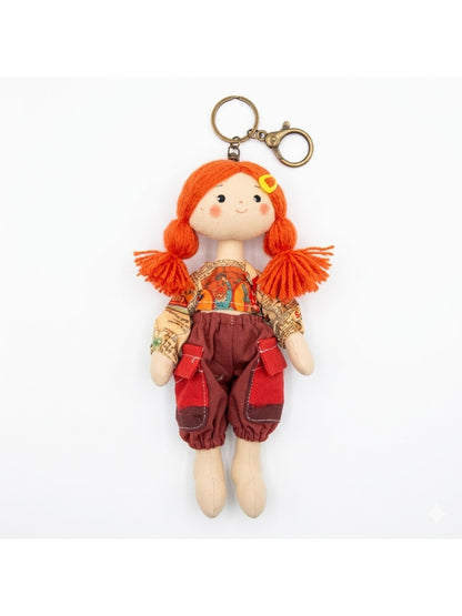 Fabric yarn doll keychain photographed on a plain background for product display