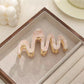 Beau hair clip placed on a wooden surface with natural lighting