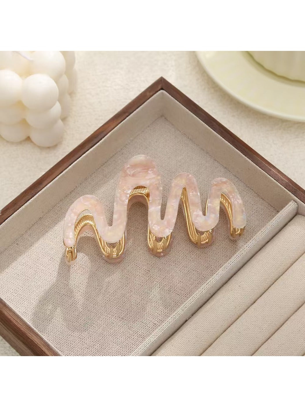 Beau hair clip placed on a wooden surface with natural lighting