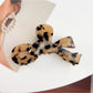Beau bow hair claw clip next to matching hair accessories on white background