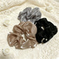 Close-up of Gifty bead embellished tulle scrunchie in soft pink on white background