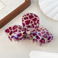 Beau bow claw clip with leopard print pattern next to fashion accessories