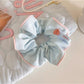 Gifty scrunchie in soft fabric with subtle stripes, shown from side angle