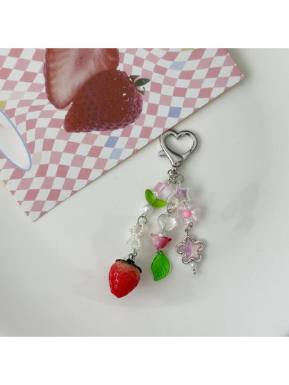 Sweet Tulip Strawberry keychain attached to a set of keys on a wooden surface