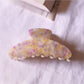 Beau tiny floral acetate claw clip shown from bottom angle highlighting clip teeth