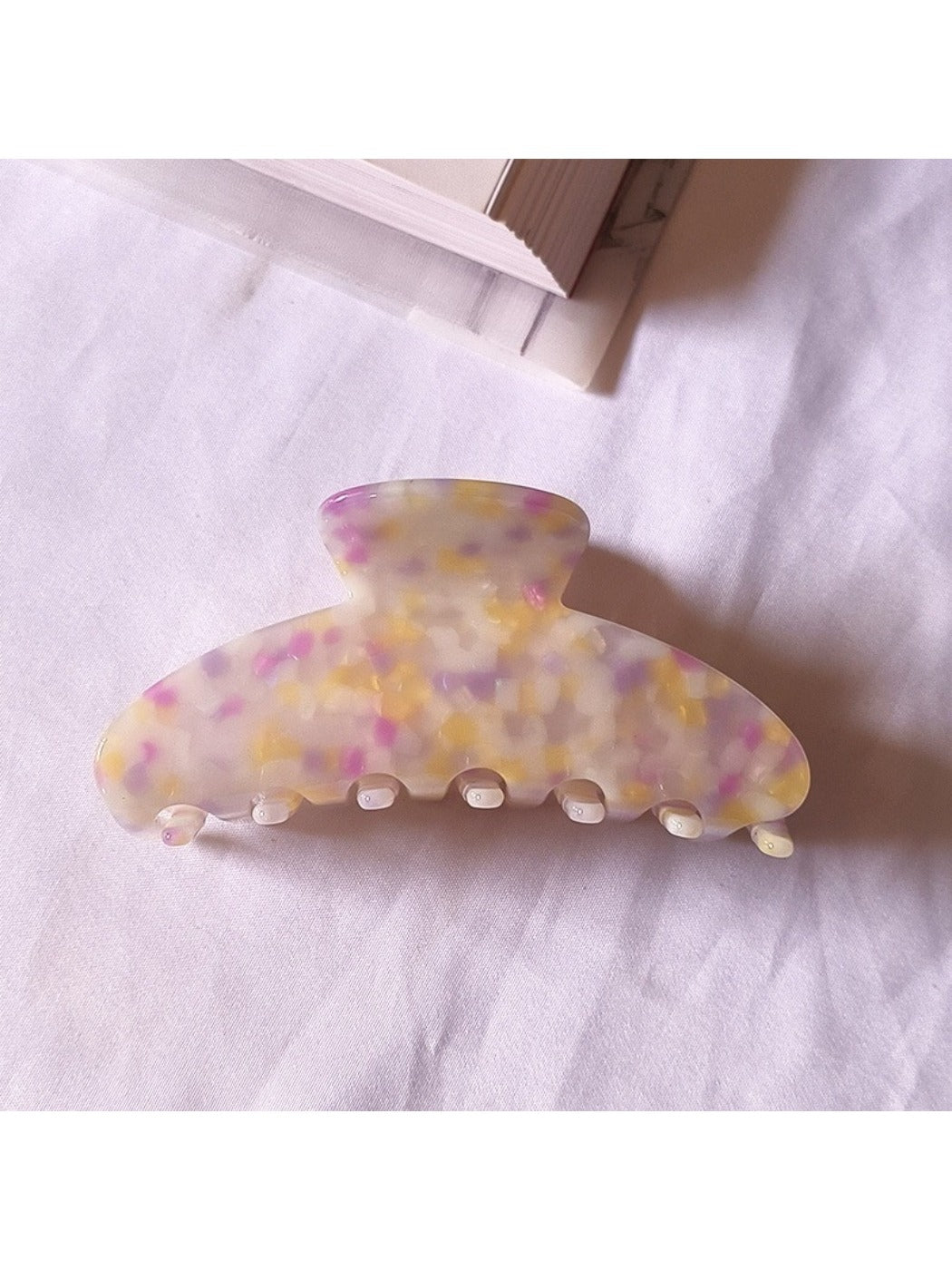 Beau tiny floral acetate claw clip shown from bottom angle highlighting clip teeth