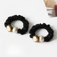 Gifty hair tie stretched to show elastic band with round black beads