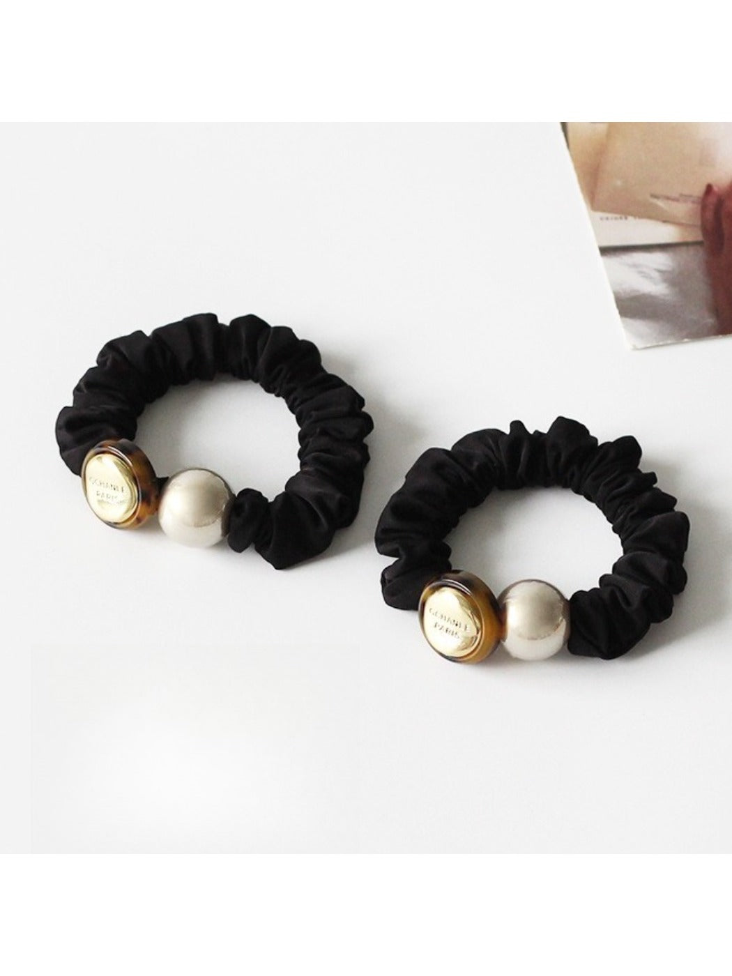 Gifty hair tie stretched to show elastic band with round black beads
