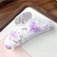 Beau hair clip held in hand showing size and colorful floral design