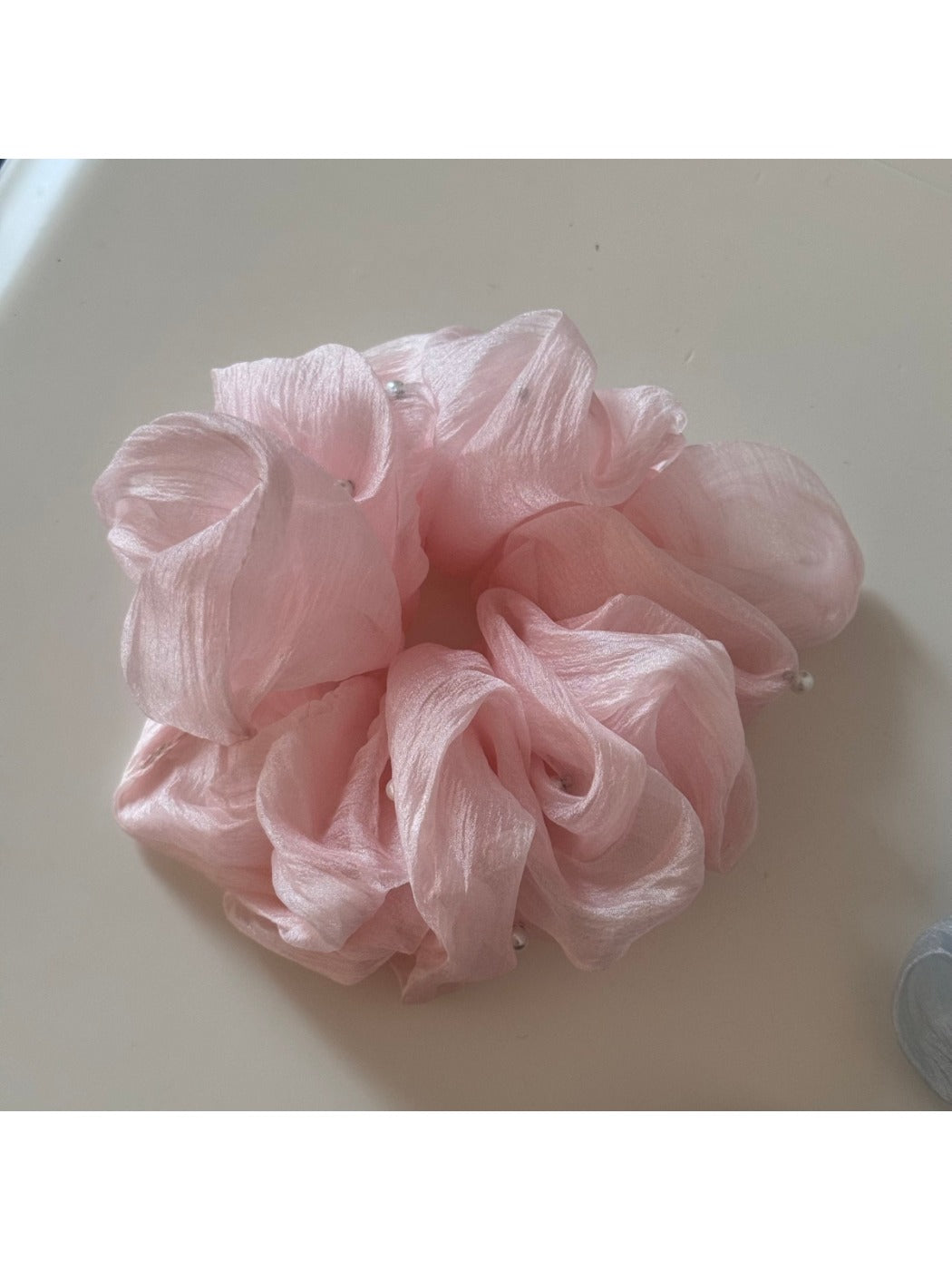 Gifty scrunchie paired with matching pastel accessories on a wooden table