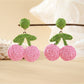 Close-up of earring hooks attached to raffia cherry shaped earrings