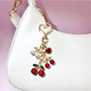 Keypus cherry charm keychain shown in hand to highlight size and detail