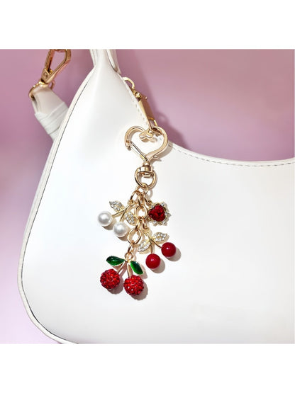Keypus cherry charm keychain shown in hand to highlight size and detail