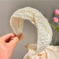 Detailed shot of pearl and crystal beads forming a bow on a black headband