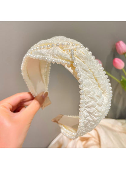 Detailed shot of pearl and crystal beads forming a bow on a black headband