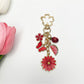 Detailed shot of the daisy charm showing petal and center design on gold keychain