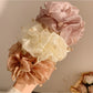 Gifty scrunchie displayed on a white background showing bead details and fabric texture