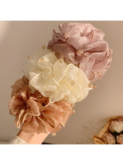 Gifty scrunchie displayed on a white background showing bead details and fabric texture