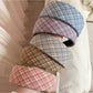 Close-up of the plaid pattern on the wide headband showing fabric texture