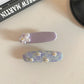 Beau sweet purple flower hair clip displayed on a white surface