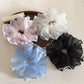 Close-up of Gifty elegant solid color ruffled scrunchie in soft fabric