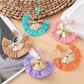 Close-up of Earedge casual style raffia fan earrings on white background