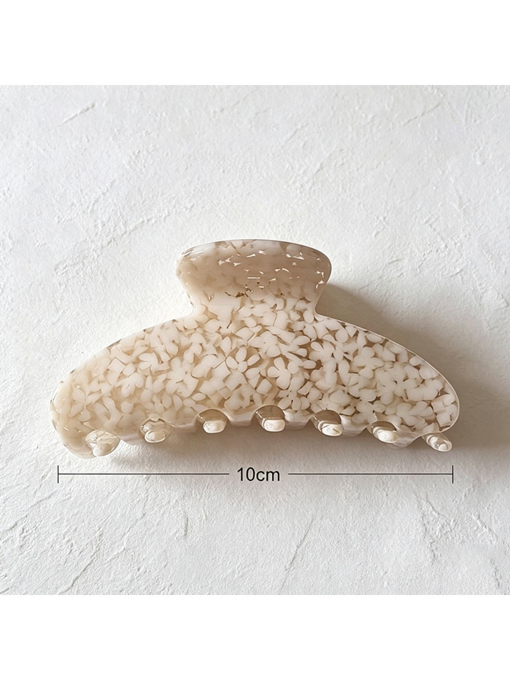 Beau tiny floral acetate claw clip held in hand showing size and design