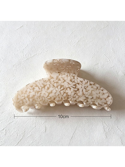 Beau tiny floral acetate claw clip held in hand showing size and design