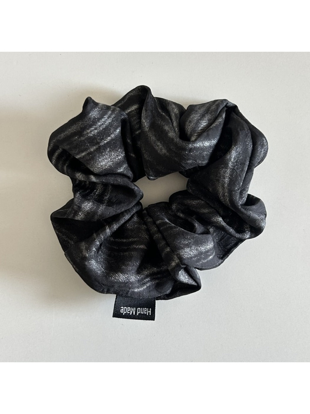 Vintage pleated fabric scrunchie wrapped around wrist as a bracelet accessory