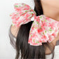 Red floral bow scrunchie styled in a ponytail on a model
