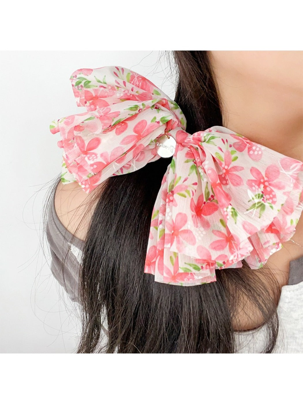 Red floral bow scrunchie styled in a ponytail on a model