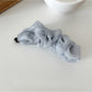 Beau tulle ruffle high ponytail claw clip shown from above on a flat surface