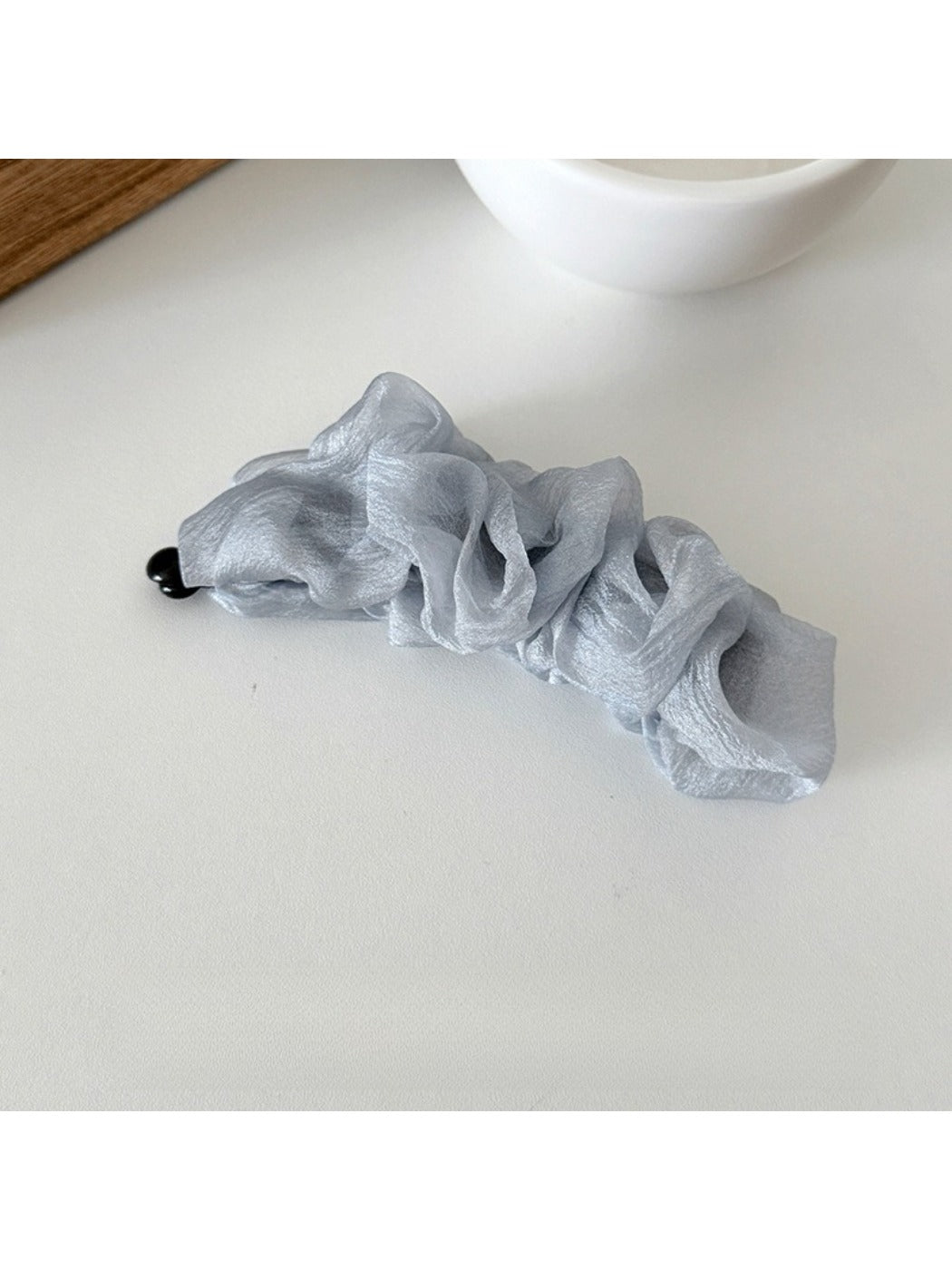 Beau tulle ruffle high ponytail claw clip shown from above on a flat surface