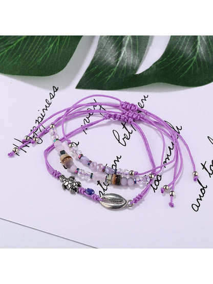 Side view of Lovra alloy charm small bead bracelet displaying bead arrangement and charm