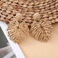 Pair of raffia woven hollow leaf shaped earrings shown from the back side